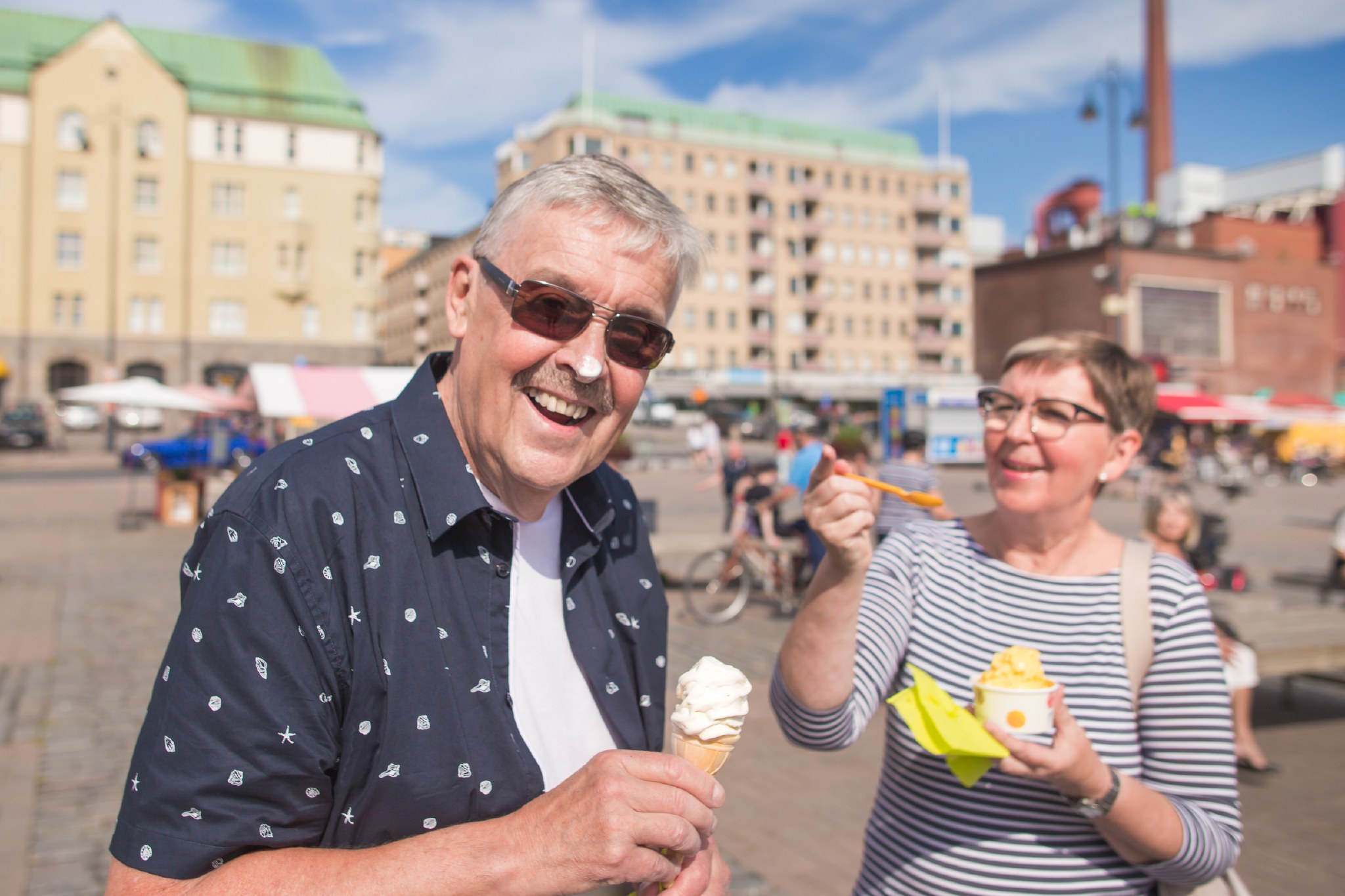 Mies ja nainen syömässä jäätelöä Laukontorilla.