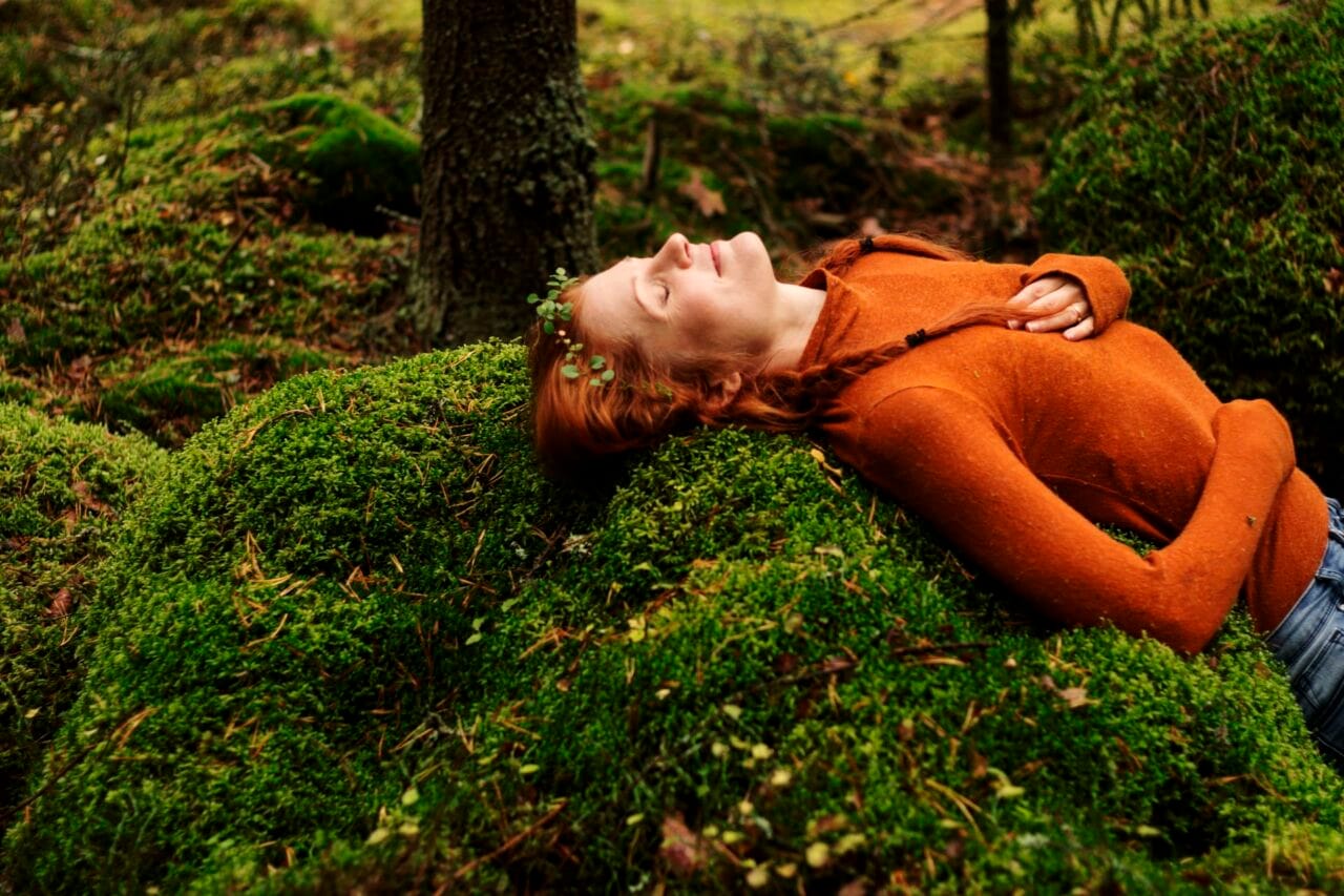 Woman on a bed of moss.