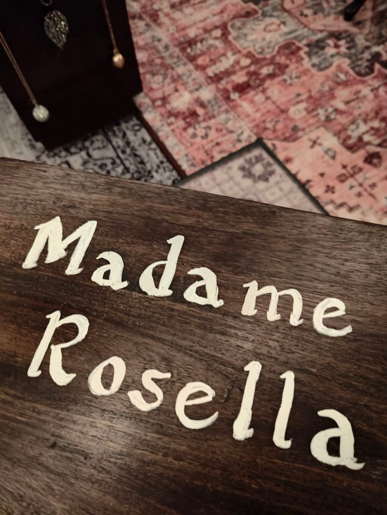 Fortune teller Madame Rosella's name painted on a wooden box inside an escape room
