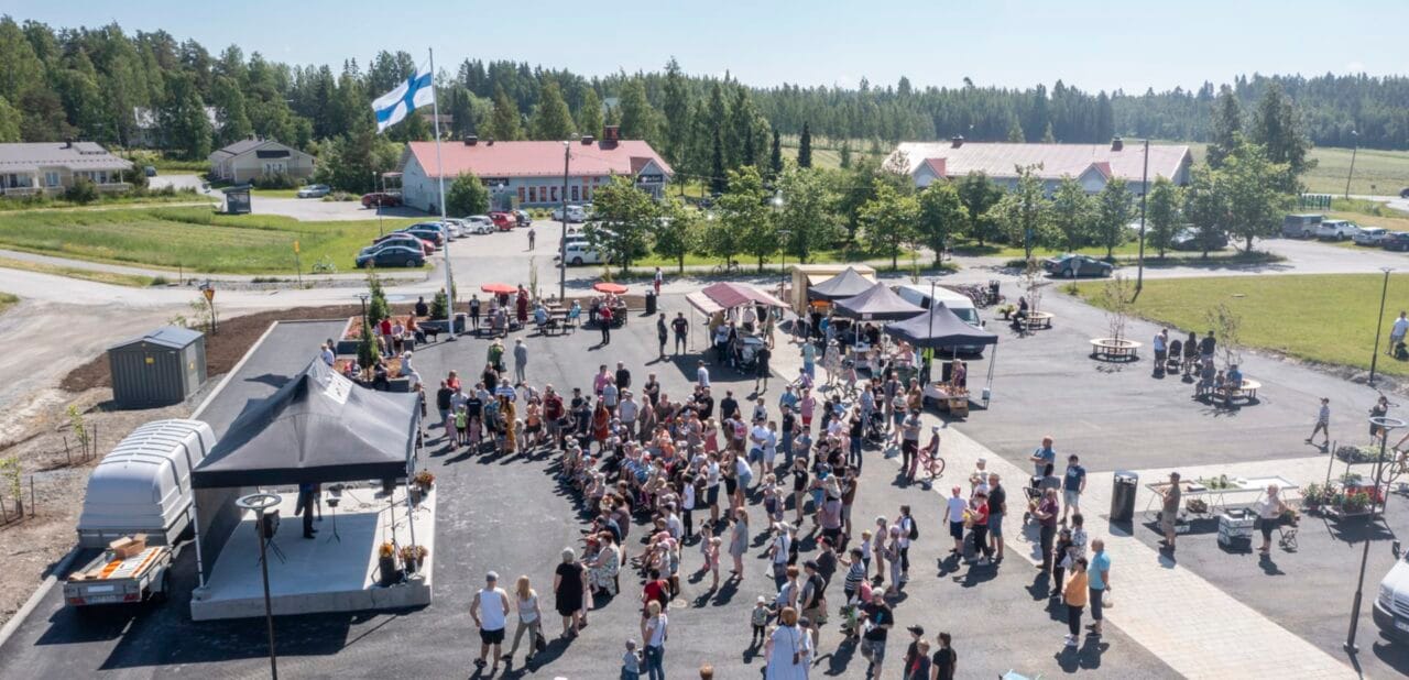 Ilmakuva Vesilahden Kirkonkylän torista, jossa seisoskelee runsaasti väkeä.