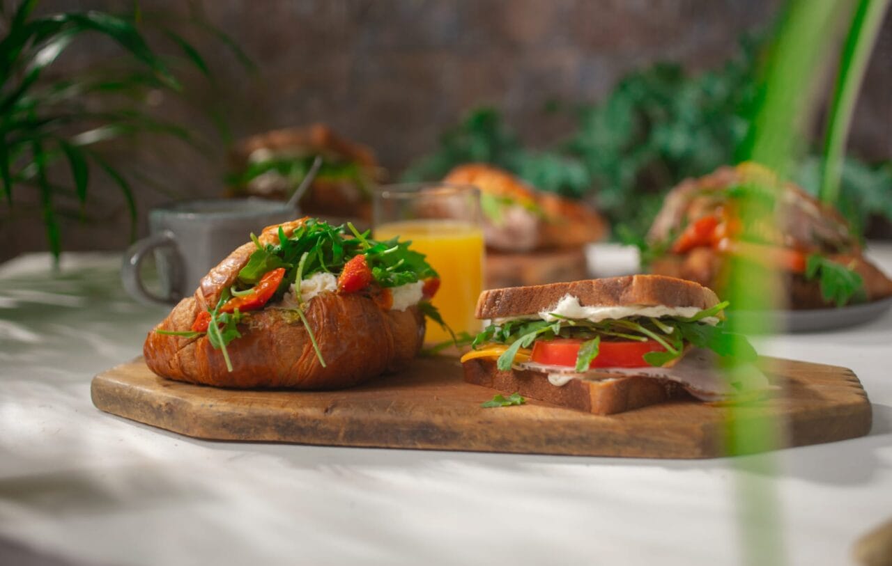 Täytetty croissant ja toast, appelsiinmehu sekä kahvi