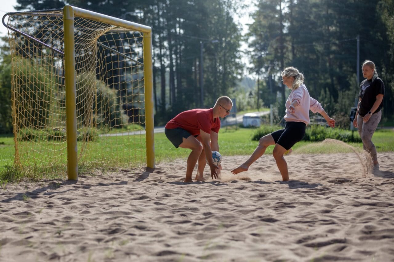 Ihmisiä pelaamassa beachfutista.