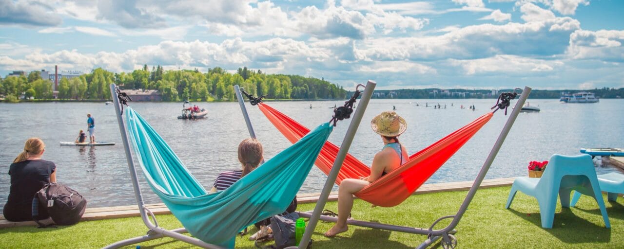 People looking at water activities in summery Eteläpuisto park.