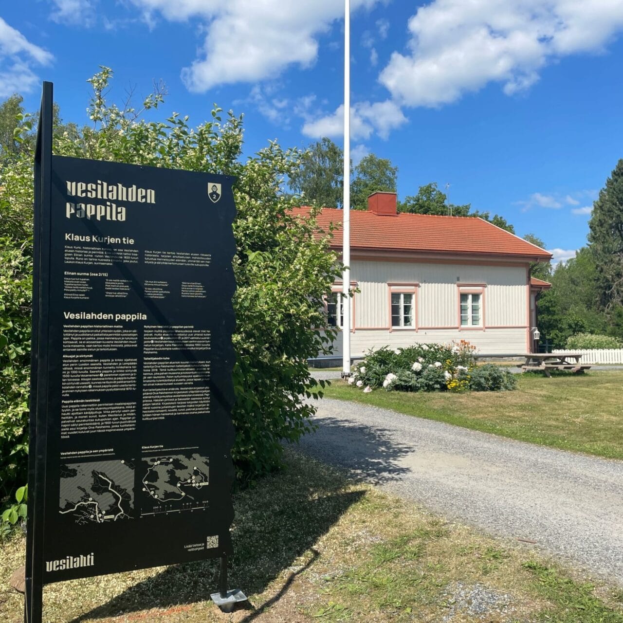 Vasemmalla edessä Klaus Kurjen tien opastetaulu, jonka taustalla näkyy Vesilahden Pappilan päärakennus.