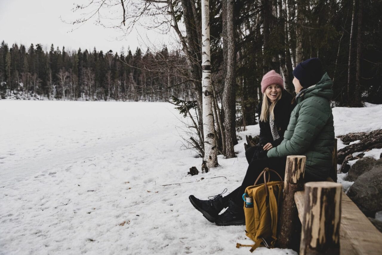 Nainen ja lapsi katsovat istuen jäätynyttä Hervannan Suolijärveä mielenreitillä.