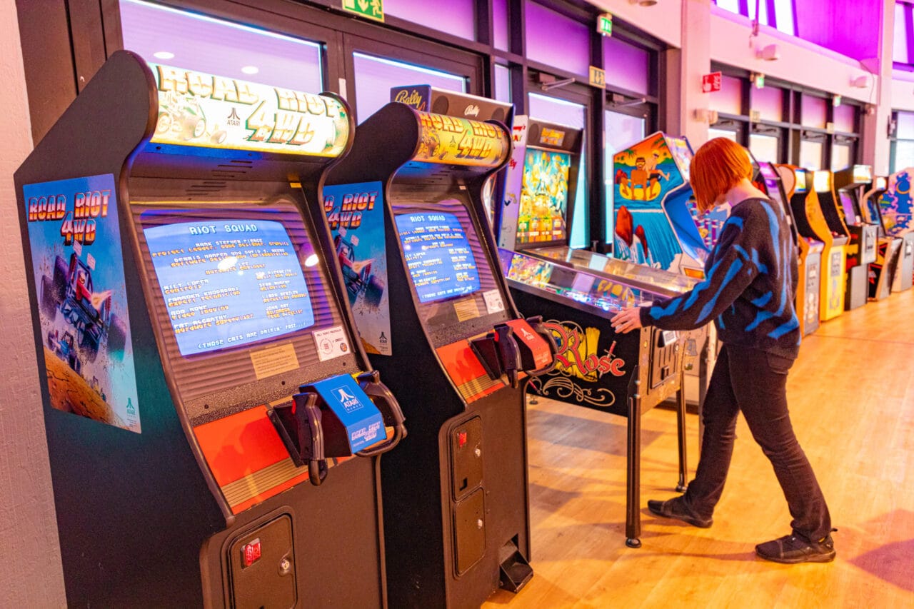 A white red-haired woman playing in Retro Arcade