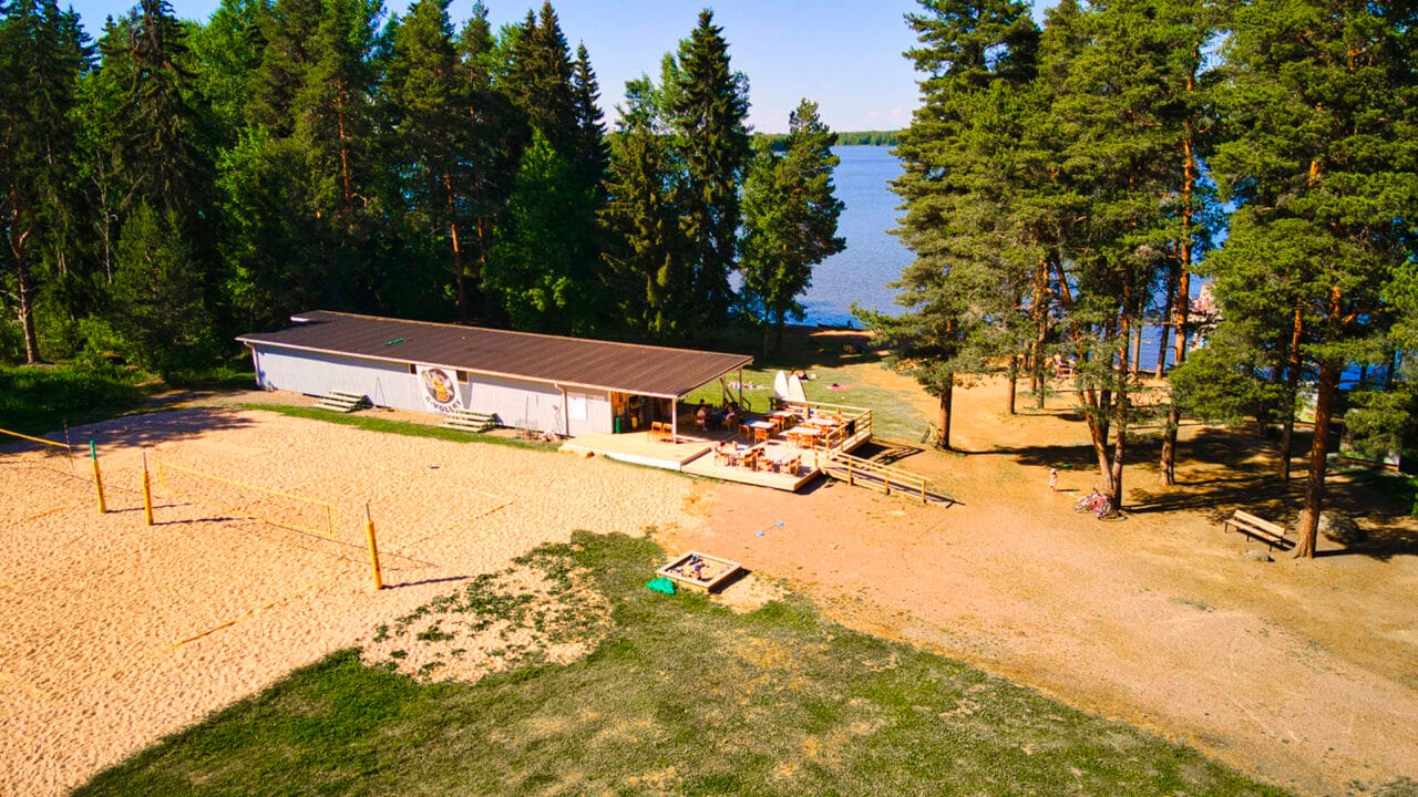 Ilmakuva Luttusen uimarannasta, jossa näkyy saunarakennus ja beach volley-kenttää