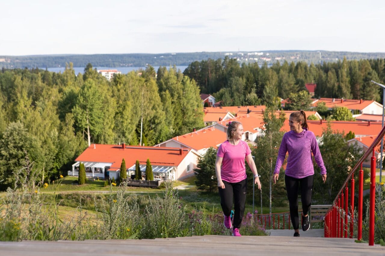 Kaksi henkilöä kiipeämässä kuntoportaita