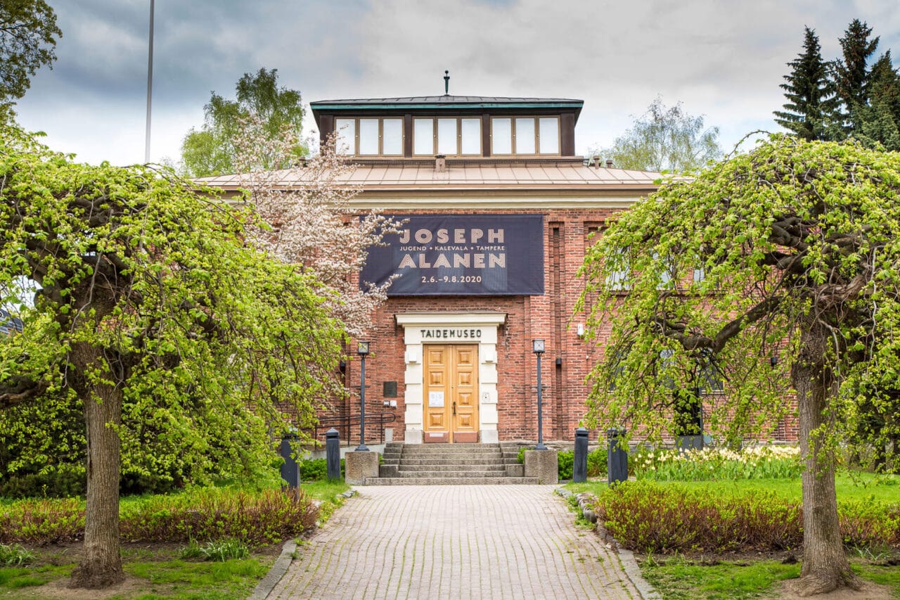 Punatiilinen museo puiden keskellä
