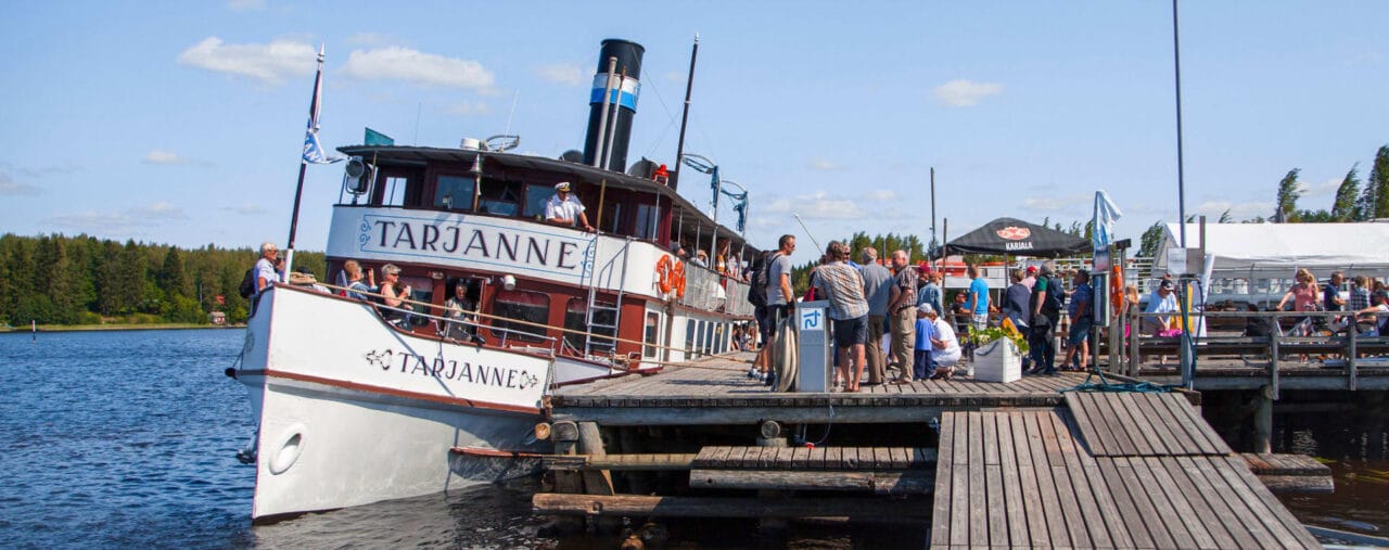 People welcome Tarjanne to a harbour.