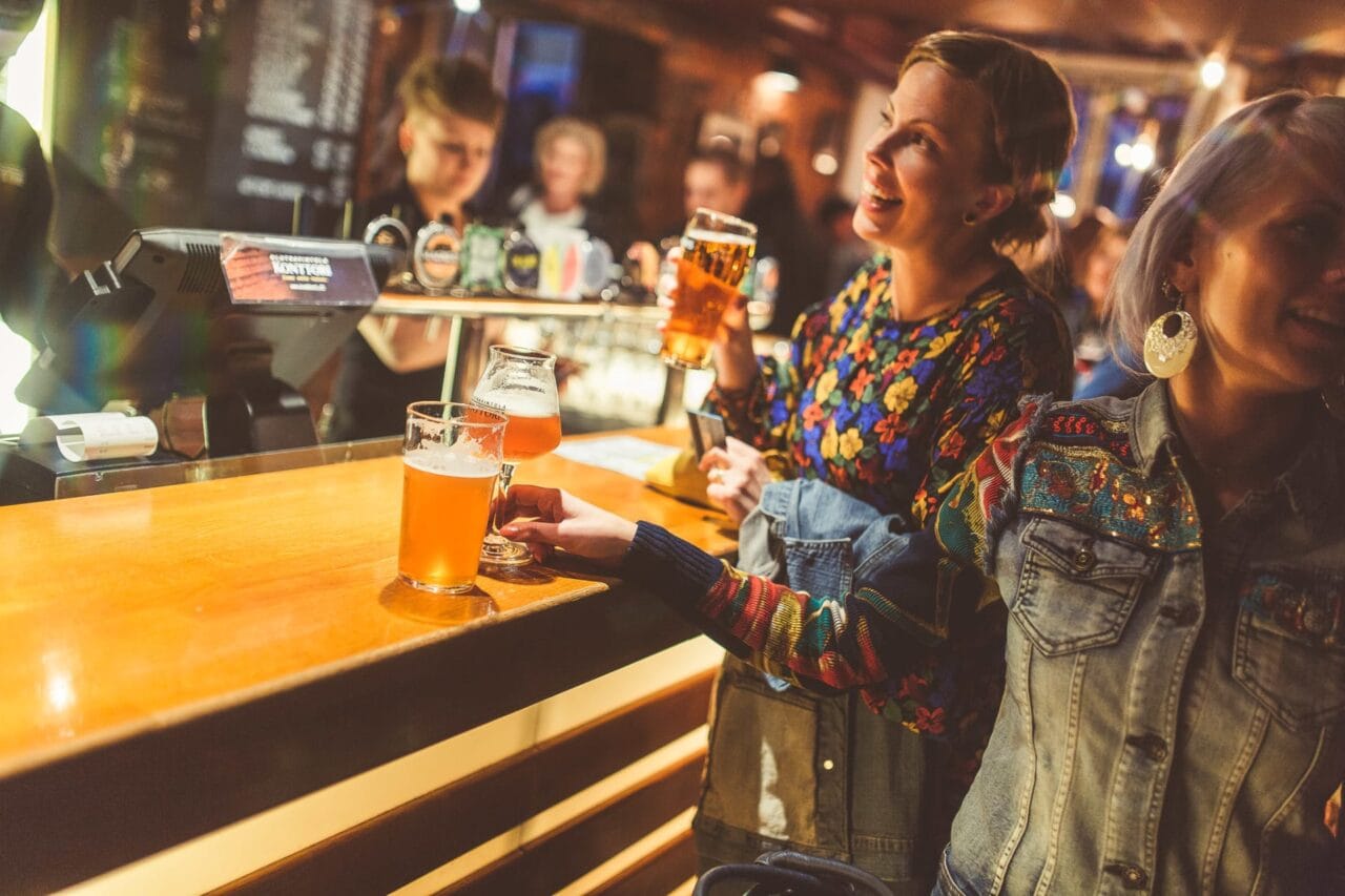 Smiling women in a pub, glass of beer in their hands