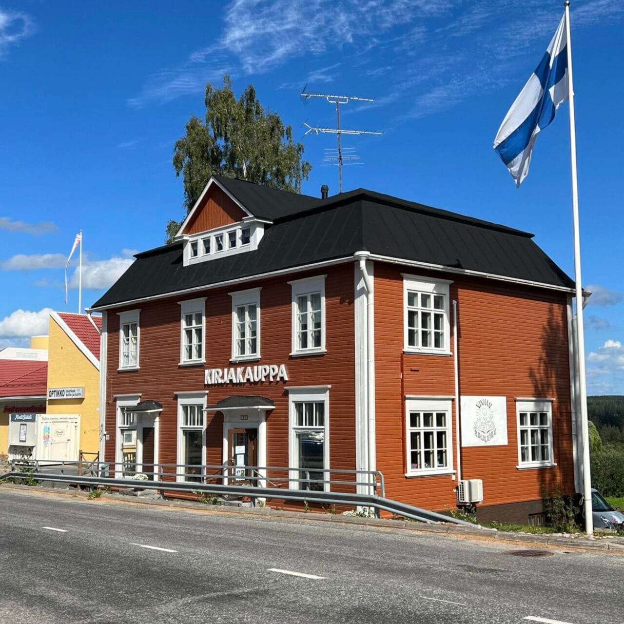Suomen vanhimpia kivijalkakirjakauppoja Ruovedellä. Perinteinen punainen puutalo valkoisine yksityiskohtineen, jonka julkisivussa lukee 'KIRJAKAUPPA'. Vieressä liehuu Suomen lippu. Historiallinen kulttuurikohde ja eläväinen osa Ruoveden perintöä.
