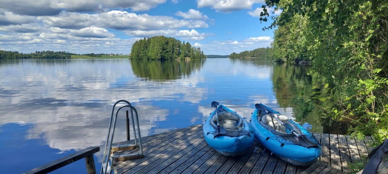 Two kayaks on a dock with a lake in the background