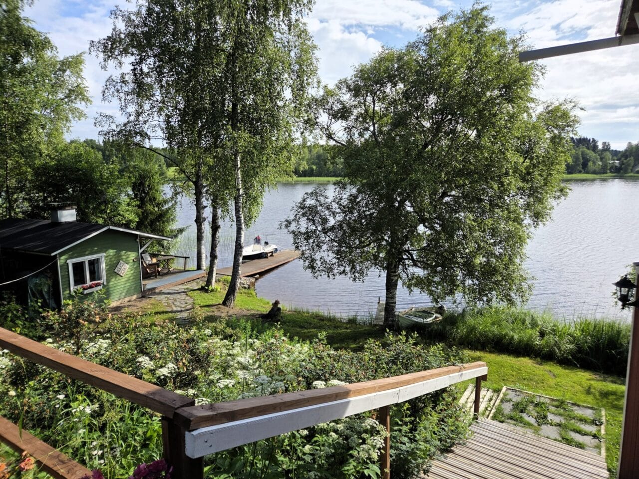 A cottage on the shore of a lake with a dock